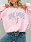 Woman wearing a pastel pink Book Lover sweatshirt with coquette bow print in soft blue, styled with jeans