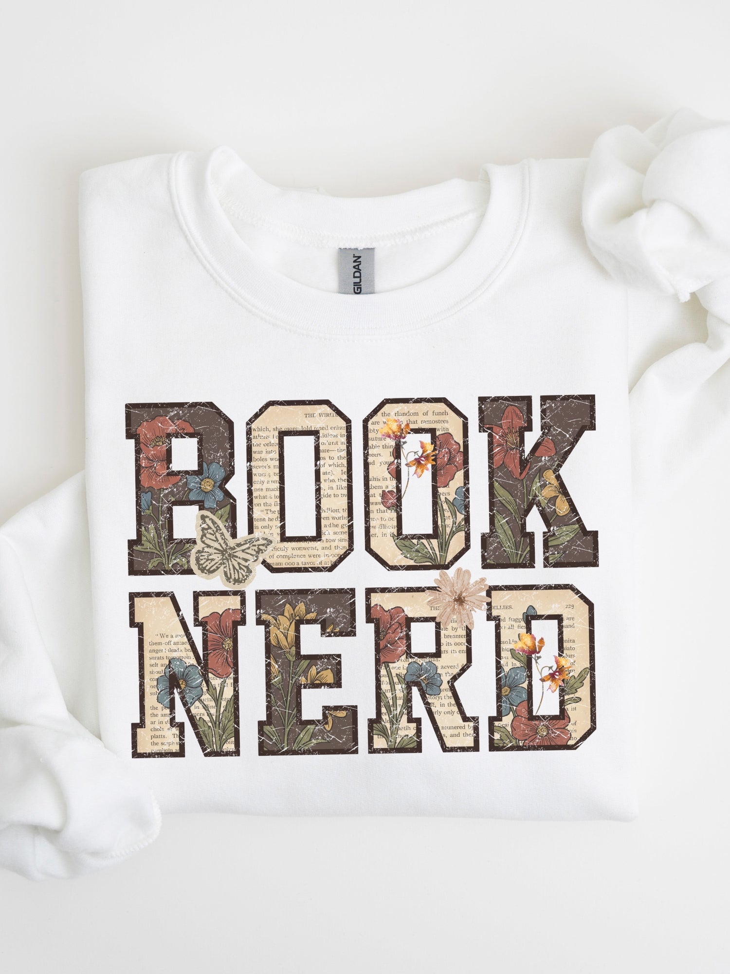 White Gildan sweatshirt featuring a vintage floral Book Nerd design with book page details and butterflies, cozy bookish sweatshirt for readers and book lovers