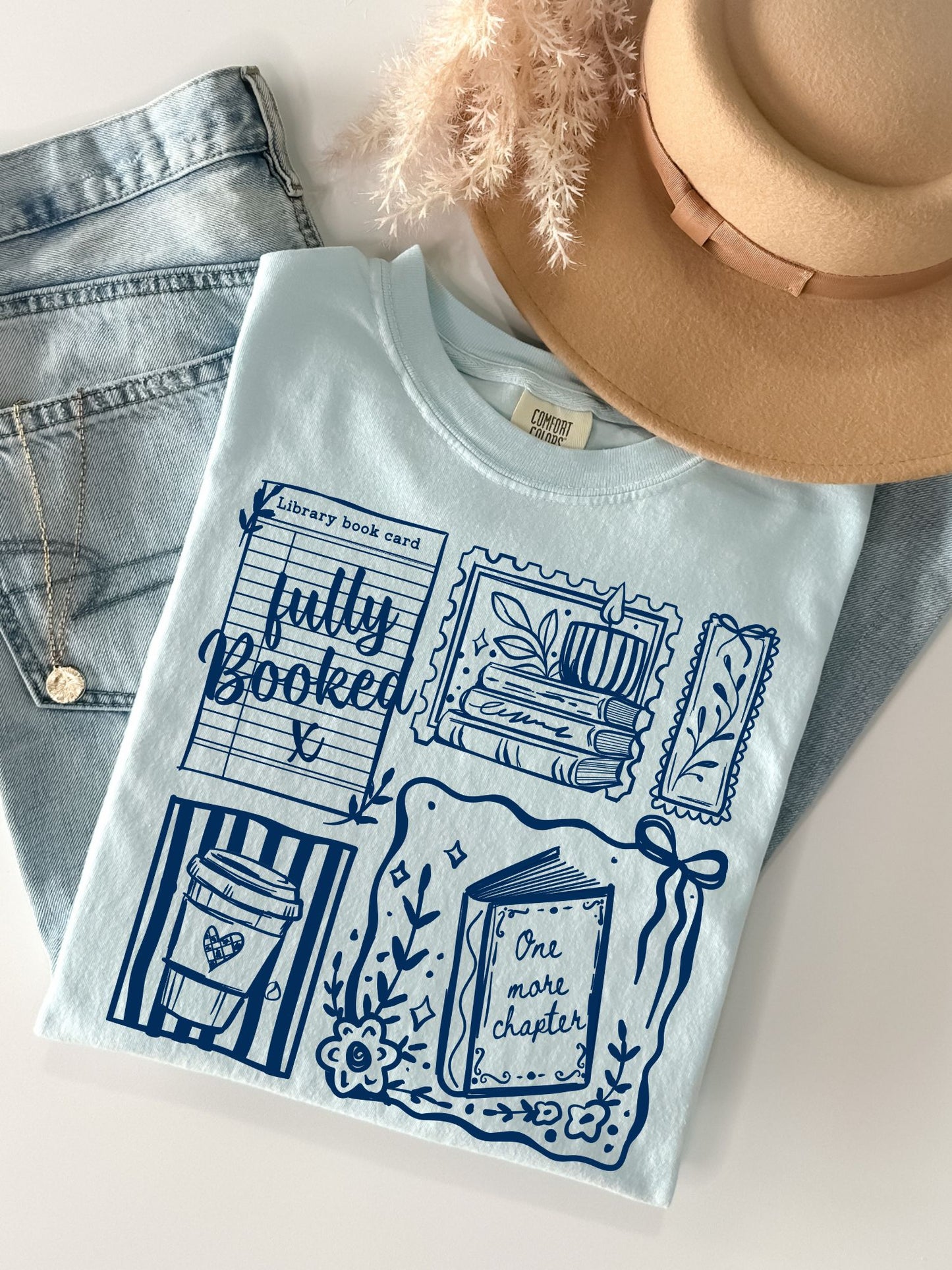 flat lay folded mockup of a blue chambray shirt featuring 5 book themed stamps