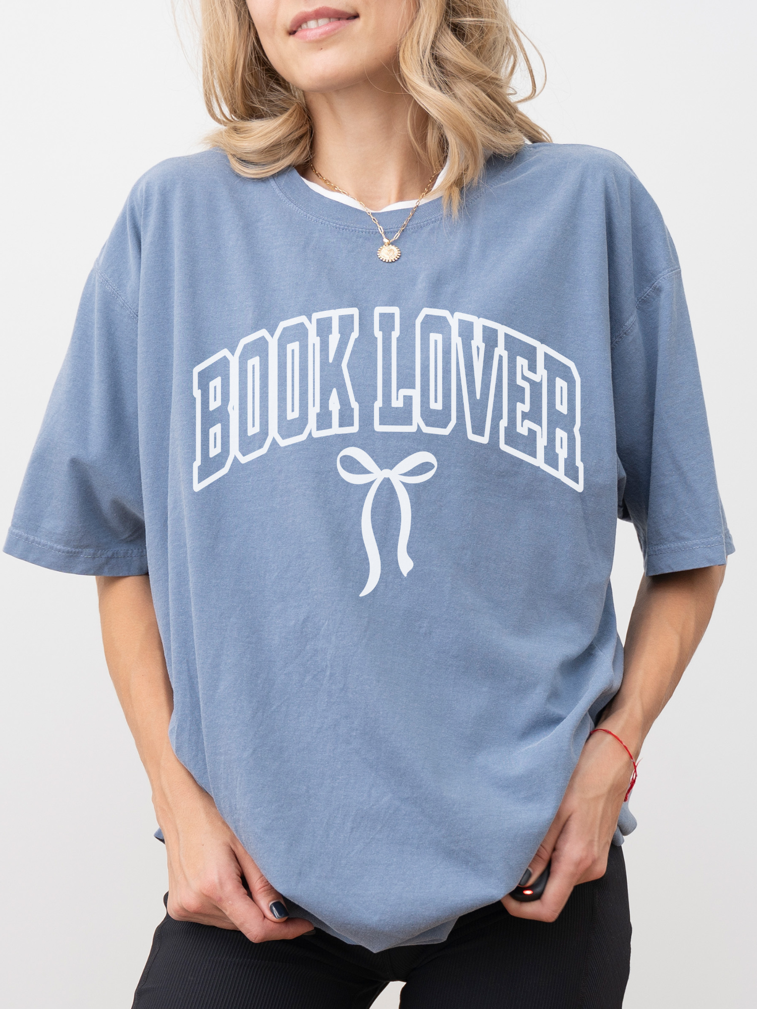 girl wearing a dusty blue jean t-shirt that says Book Lover with a bow in varsity block font