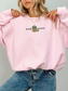 woman wearing a pink sweatshirt that says book worm with a cute green worm in glasses reading a book