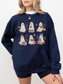 A woman wearing a navy blue crewneck sweatshirt with a graphic of six cute cartoon ghosts reading books in an autumn theme, paired with black bike shorts against a plain white background.