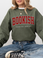 woman wearing forest green sweatshirt with red varsity "Bookish" text and white "Reading Addict" subtitle