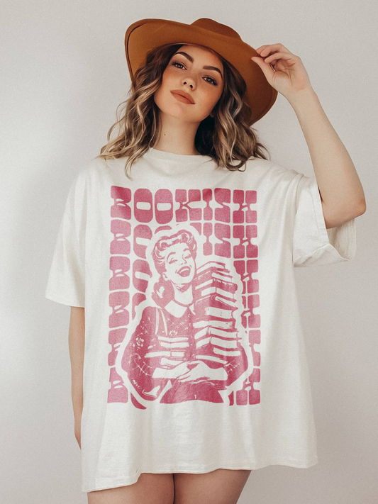 woman in wide-fit white bookish t-shirt with bold pink retro print and cowboy hat