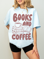 woman wearing a chambray Comfort Colors shirt featuring a books and coffee graphic with stacked books, an open book, and a steaming coffee cup, oversized reader shirt for book lovers and coffee enthusiasts
