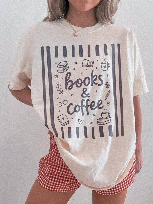 woman wearing an ivory Comfort Colors shirt featuring a books and coffee graphic with books coffee mugs reading icons stars and cozy book lover artwork paired with red gingham shorts for a relaxed reader aesthetic