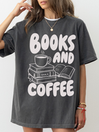 woman wearing a pepper Comfort Colors shirt featuring a books and coffee design with illustrated stacked books, open book, and coffee cup, cozy oversized bookworm shirt for readers and librarians