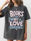 woman wearing a pepper comfort colors t shirt featuring books are my love language design with pastel pink and blue typography books hearts and open book artwork for bookworms