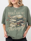 Woman in moss green Books Are My Therapy T-shirt featuring hand-drawn books, daisies, and coffee cup