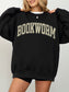 girl standing wearing a black sweatshirt that says "bookworm" across the top in a jersey sport font