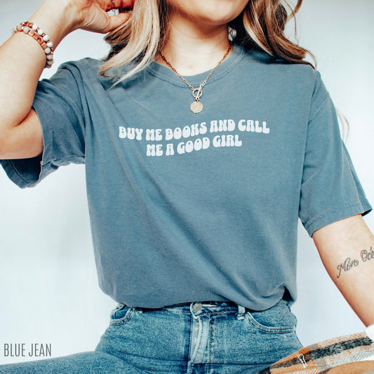 woman wearing blue jean shirt that says buy me books and call me a good girl paired with jeans and layered necklaces