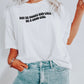 woman wearing white shirt that says buy me books and call me a good girl tucked into light wash jeans