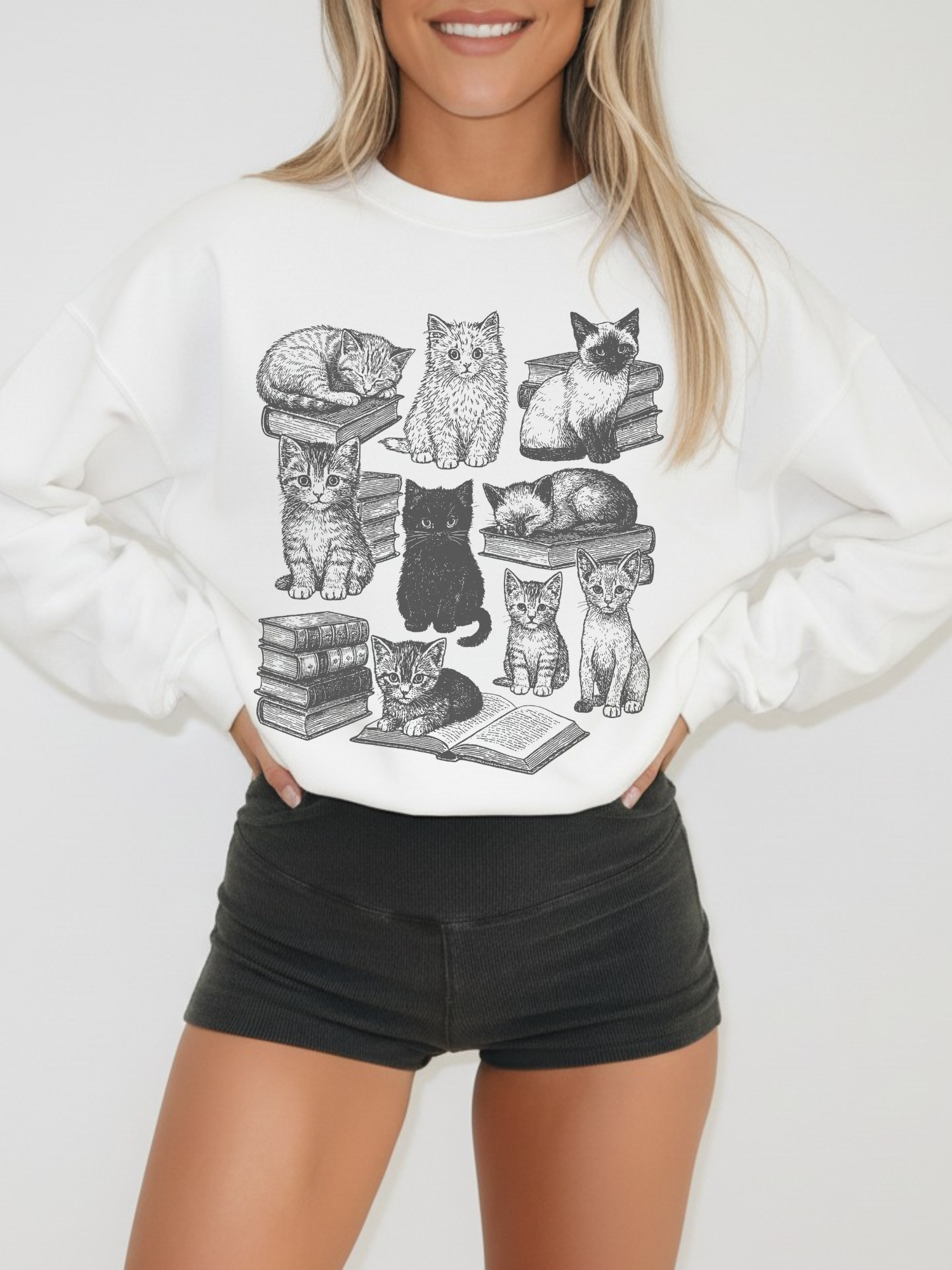 smiling model in white cats and books crewneck sweatshirt with detailed feline line art