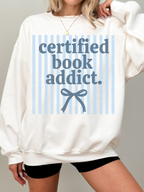 model wearing certified book addict oversized white sweatshirt with blue stripe design and bow detail styled with shorts