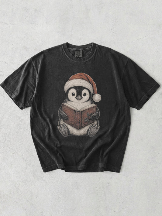 Graphite Comfort Colors bookish shirt featuring a cute penguin wearing a Santa hat and reading a Christmas book for readers and book lovers