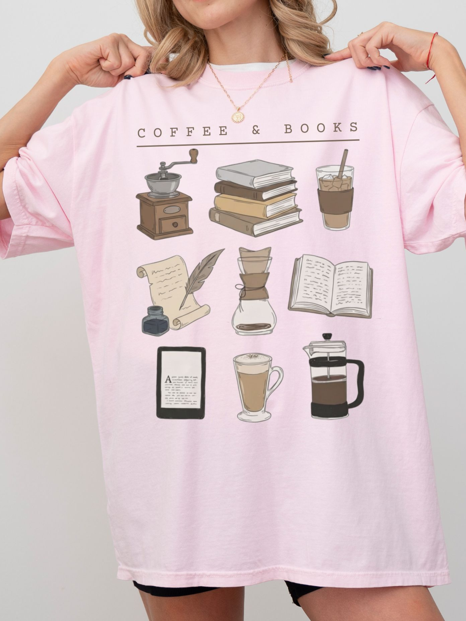 pink pastel reading shirt with coffee and books drawings, worn by blonde woman