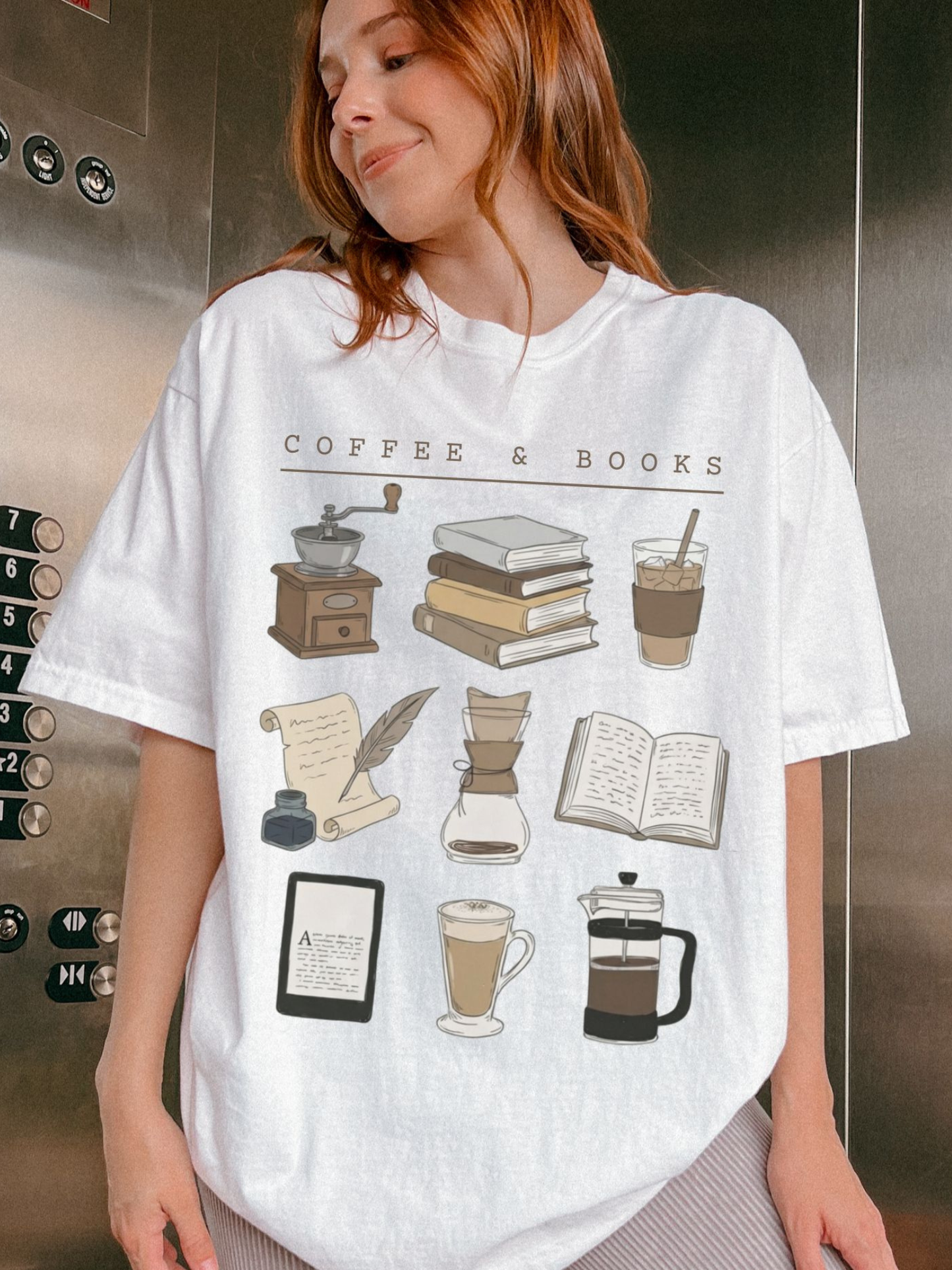 red-haired woman in elevator wearing white book and coffee tee with stack of books and iced coffee