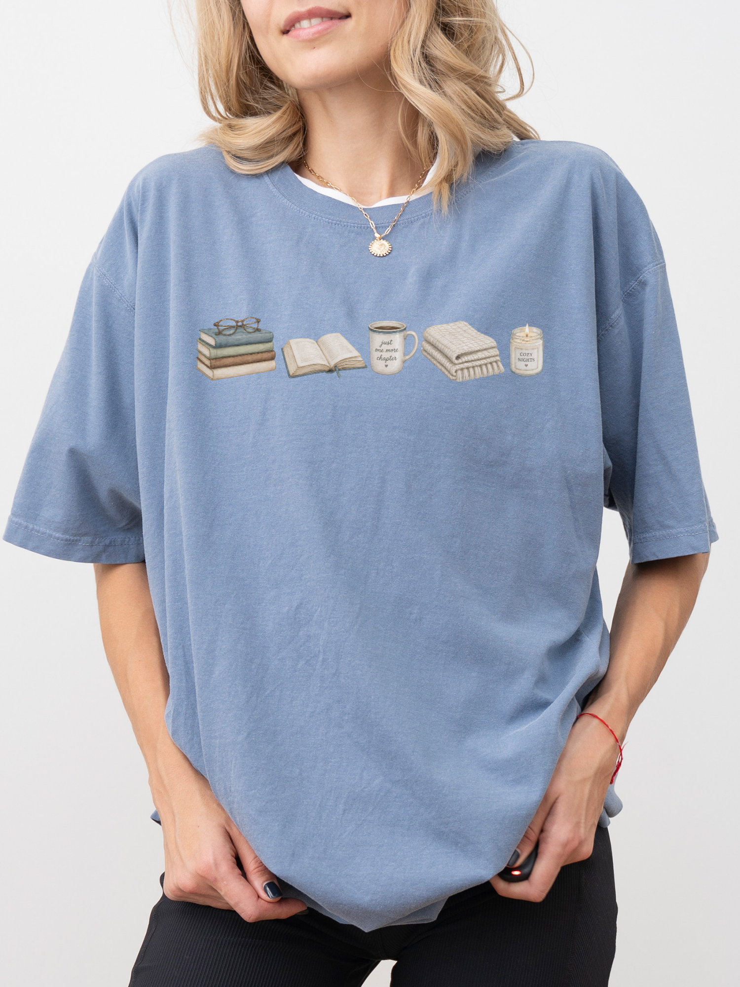 Woman wearing a blue jean Comfort Colors book lover shirt with books, coffee mug, blanket and cozy reading candle design