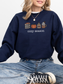 girl sitting in navy sweatshirt with cozy season fall icons including pumpkin, books, and coffee