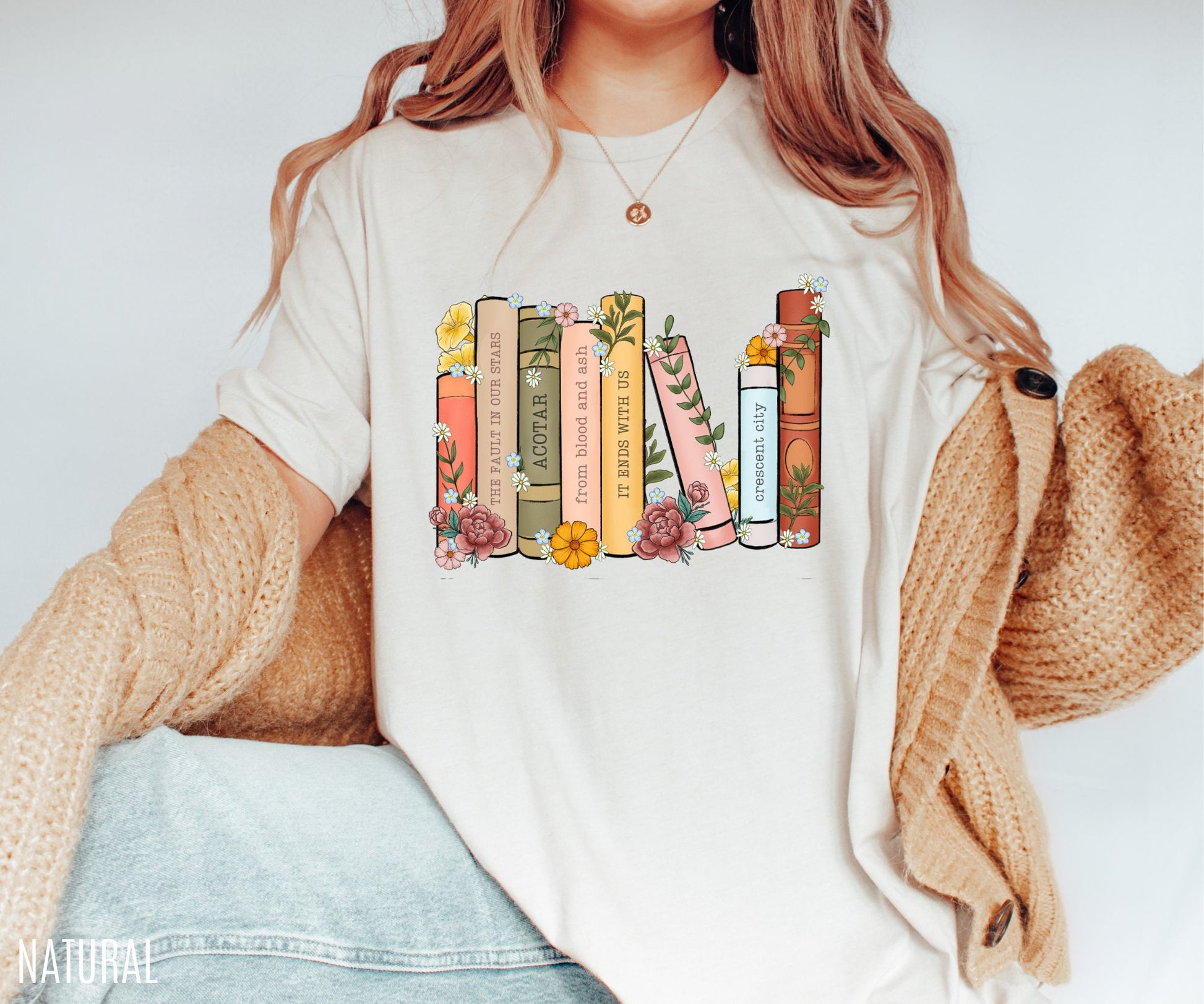 woman in natural t-shirt featuring pastel floral book spines with popular book titles on bookshelf design
