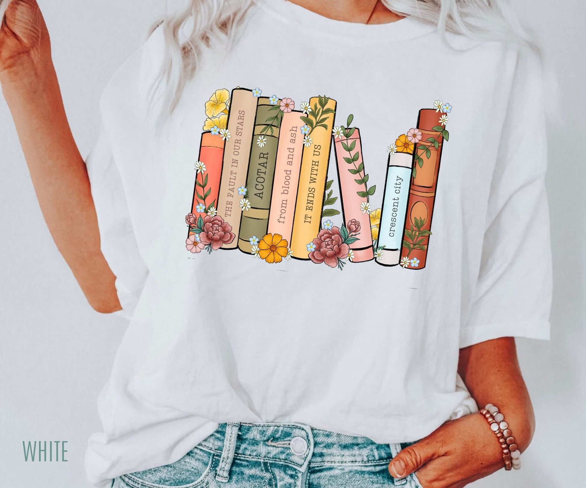 woman in white tee with custom bookshelf print featuring floral book stack and reader favorites