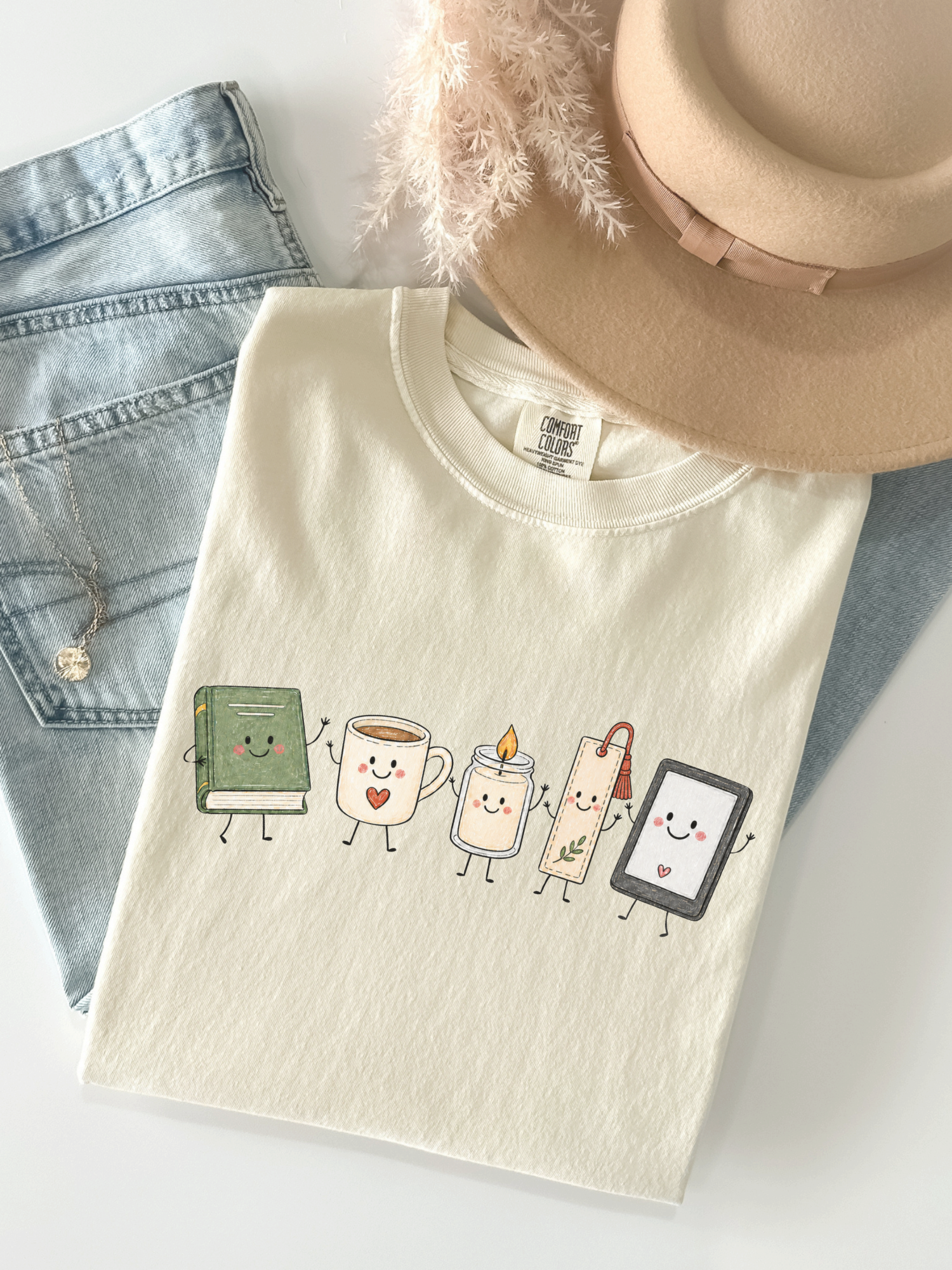 Comfort Colors reading shirt featuring cute book, coffee mug, candle, bookmark and e-reader characters in Ivory