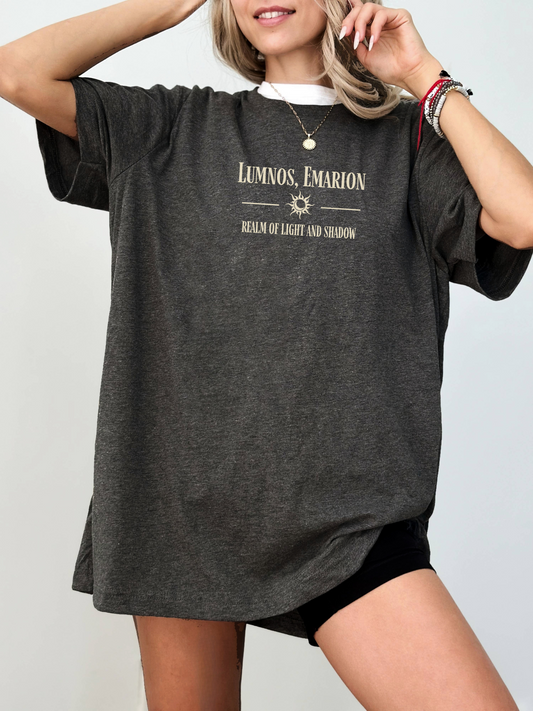 Oversized dark grey heather shirt with off-white print featuring the words "Lumnos, Emarion - Realm of Light and Shadow", styled with layered necklaces and black biker shorts