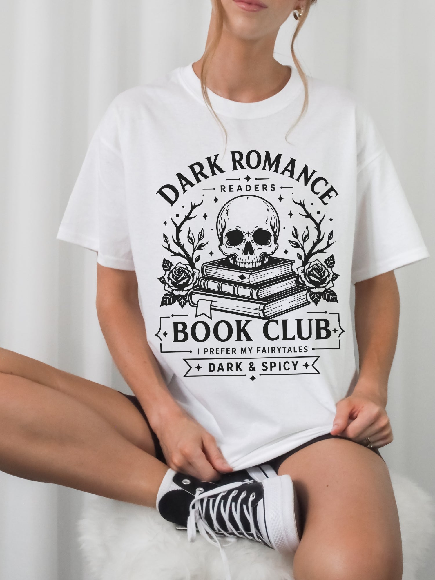Model wearing a White bookish shirt featuring Dark Romance Readers Book Club text with skull, stacked books and roses graphic for dark romance readers