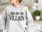 woman wearing ash grey sweatshirt with Dibs on the Villain print in black 