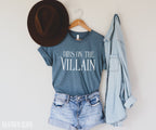 heather slate blue Dibs on the Villain t-shirt styled with jean shorts, hat, and denim shirt