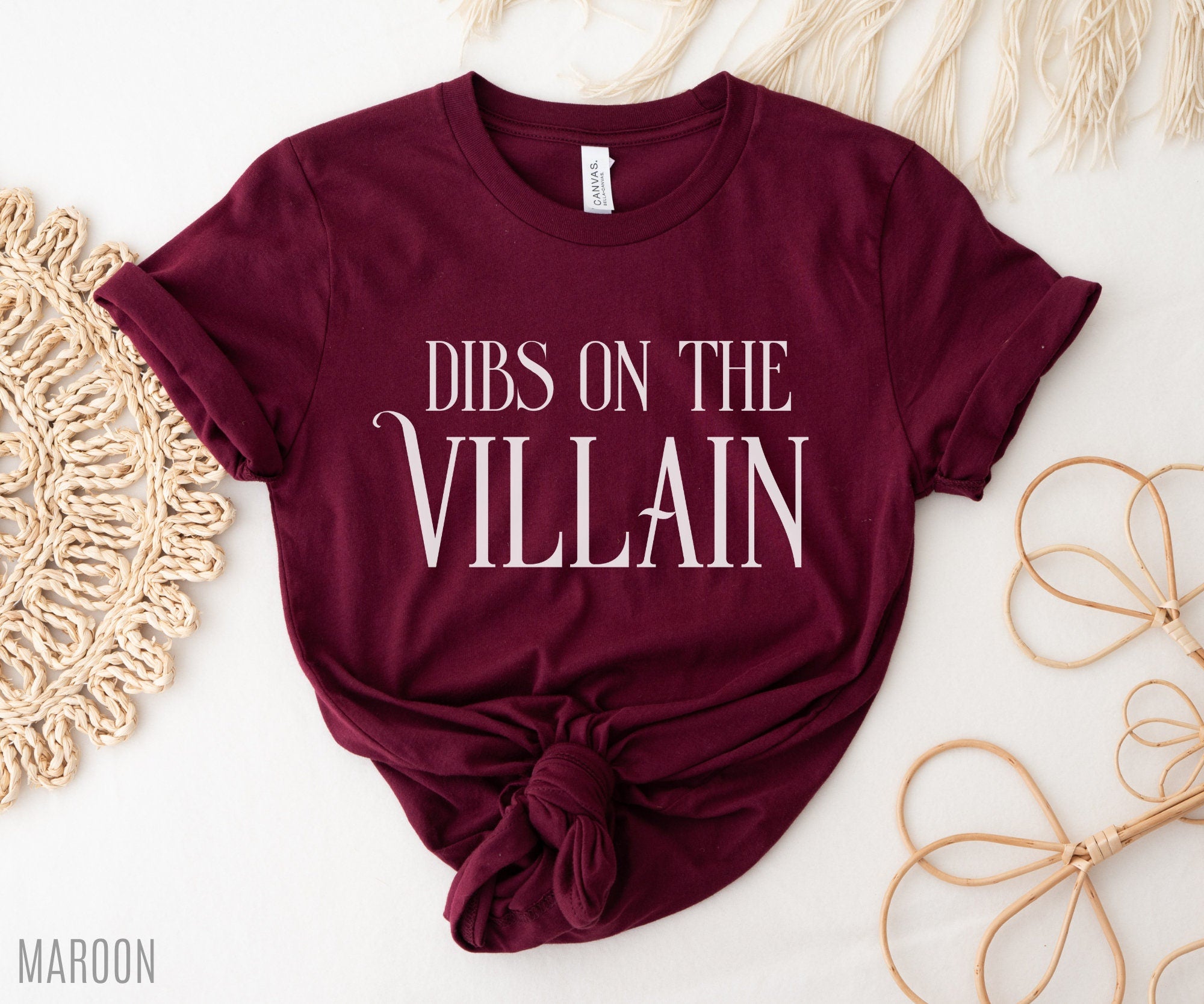 flat lay of maroon Dibs on the Villain t-shirt with knotted hem and soft bookish styling