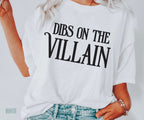 woman wearing oversized white Dibs on the Villain t-shirt with black text, styled with denim