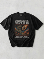 flay lay of a graphite tshirt with a retro graphic that says "dinosaurs didn't read and look what happened to them"