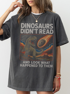 Woman wearing a pepper oversized t shirt with funny dinosaur graphic and text dinosaurs didnt read and look what happened to them meteor illustration