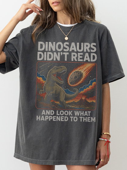 Woman wearing a pepper oversized t shirt with funny dinosaur graphic and text dinosaurs didnt read and look what happened to them meteor illustration