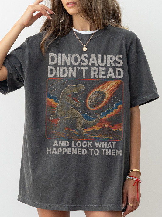 Woman wearing a pepper oversized t shirt with funny dinosaur graphic and text dinosaurs didnt read and look what happened to them meteor illustration