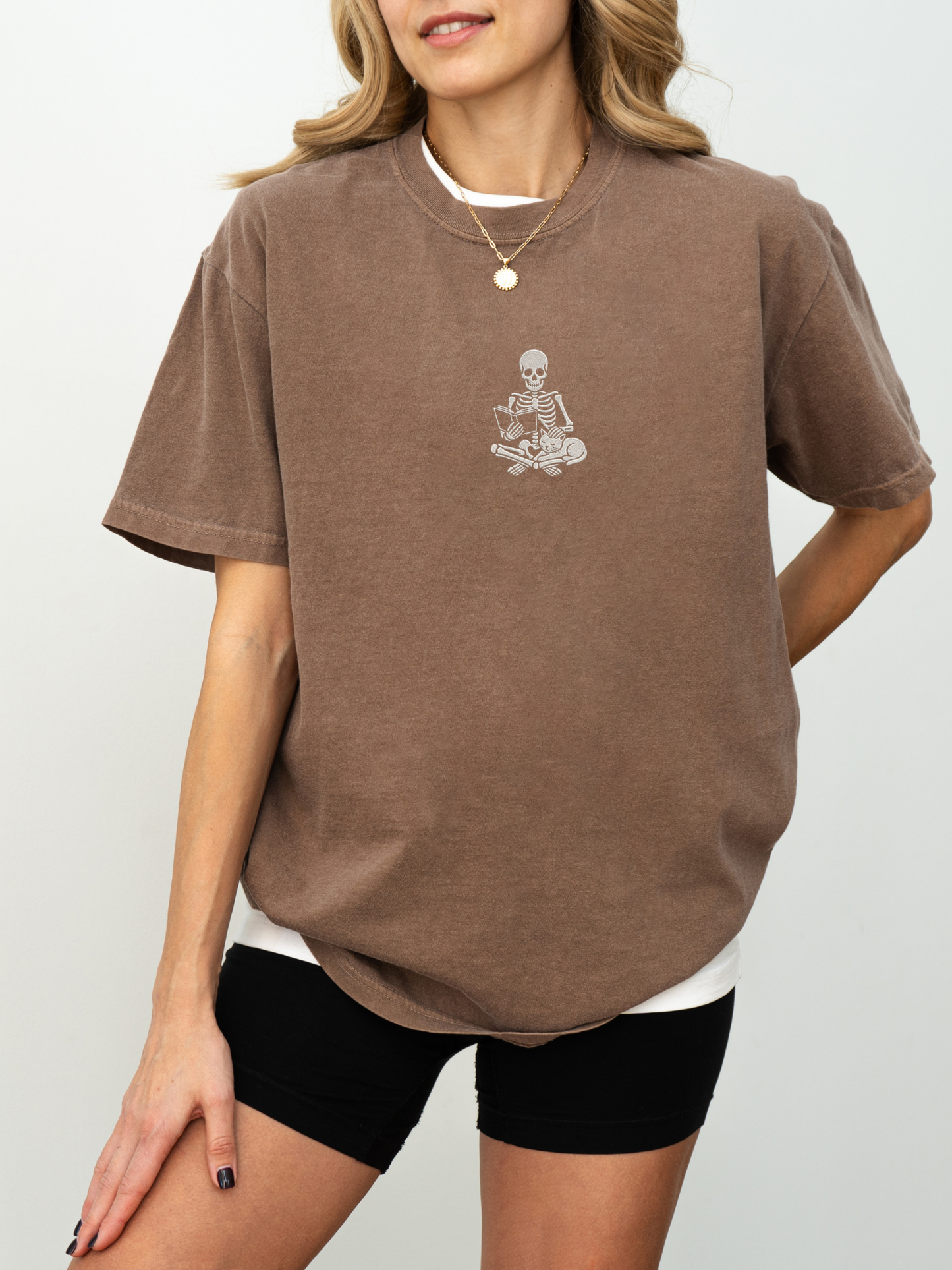Espresso Comfort Colors book lover shirt with embroidered skeleton reading a book beside a cat