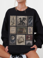Woman wearing black sweatshirt with fantasy postage stamp collage featuring enemies to lovers text dragon moon books flowers and gothic fantasy castle artwork