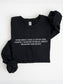A folded black fantasy reader sweatshirt with “Ever Since I Was a Little Girl I Knew I Wanted to Read About Dragons and Magic”