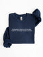 A navy blue folded crewneck sweatshirt with white text reading 'EVER SINCE I WAS A LITTLE GIRL. I KNEW I WANTED TO READ TRASH' on the chest, displayed on a clean white background.