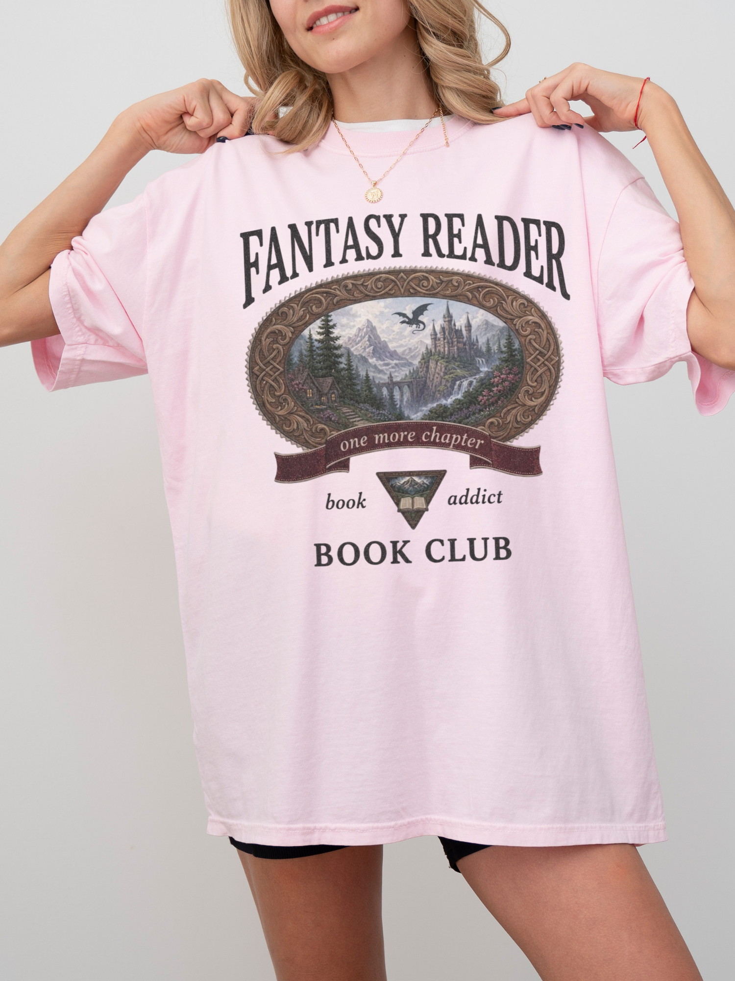 woman wearing a blossom Comfort Colors Fantasy Reader Book Club shirt with fantasy landscape artwork, dragon illustration, and one more chapter book lover design