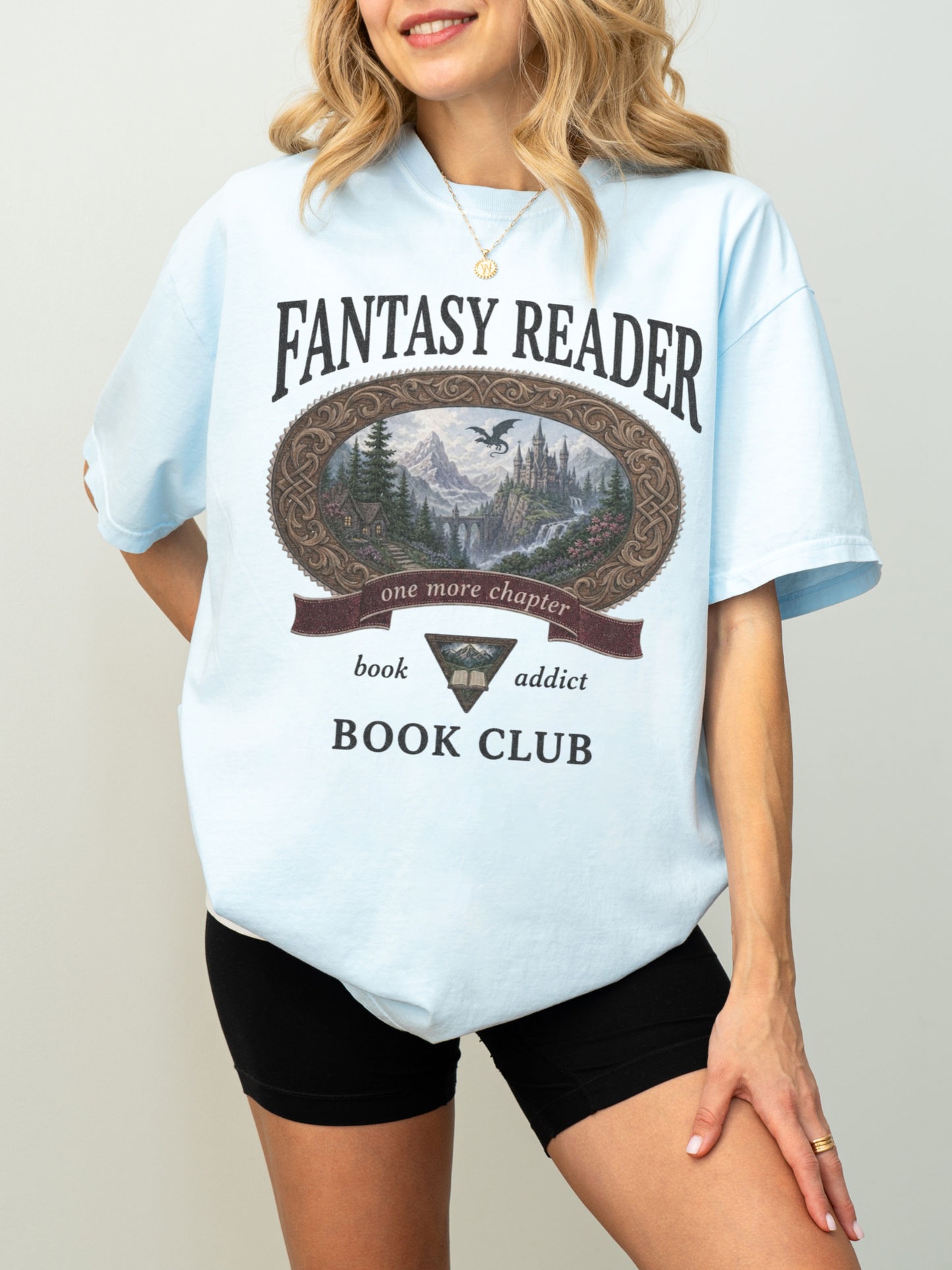 woman wearing a chambray Comfort Colors Fantasy Reader Book Club shirt featuring a castle, dragon, mountains, and fantasy reader graphic for bookworms