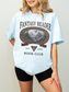 woman wearing a chambray Comfort Colors Fantasy Reader Book Club shirt featuring a castle, dragon, mountains, and fantasy reader graphic for bookworms