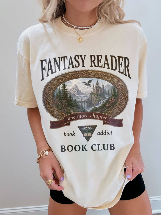 woman wearing an ivory Comfort Colors Fantasy Reader Book Club shirt with fantasy landscape artwork, dragon, castle, and book addict graphic for romantasy fans