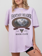 woman wearing an orchid Comfort Colors Fantasy Reader Book Club shirt featuring a fantasy castle scene, dragon artwork, and one more chapter design for fantasy readers