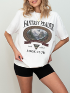 woman wearing a white Comfort Colors Fantasy Reader Book Club shirt featuring a fantasy castle, dragon, mountain scenery, and one more chapter design for fantasy book lovers and book club members