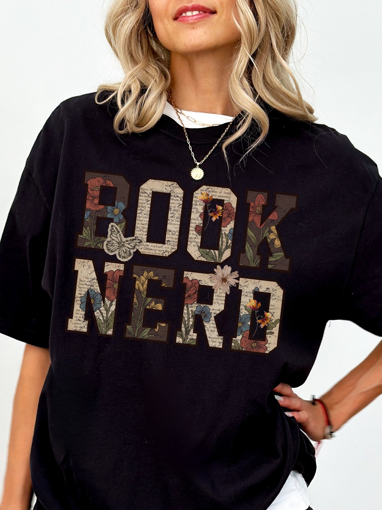 Black Comfort Colors shirt modeled with a vintage floral Book Nerd graphic featuring book pages, flowers and butterflies, bookish t shirt for readers and book lovers