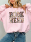 Light Pink Gildan sweatshirt featuring a floral Book Nerd design with vintage book pages, colorful flowers and butterflies, cozy book lover sweatshirt for readers