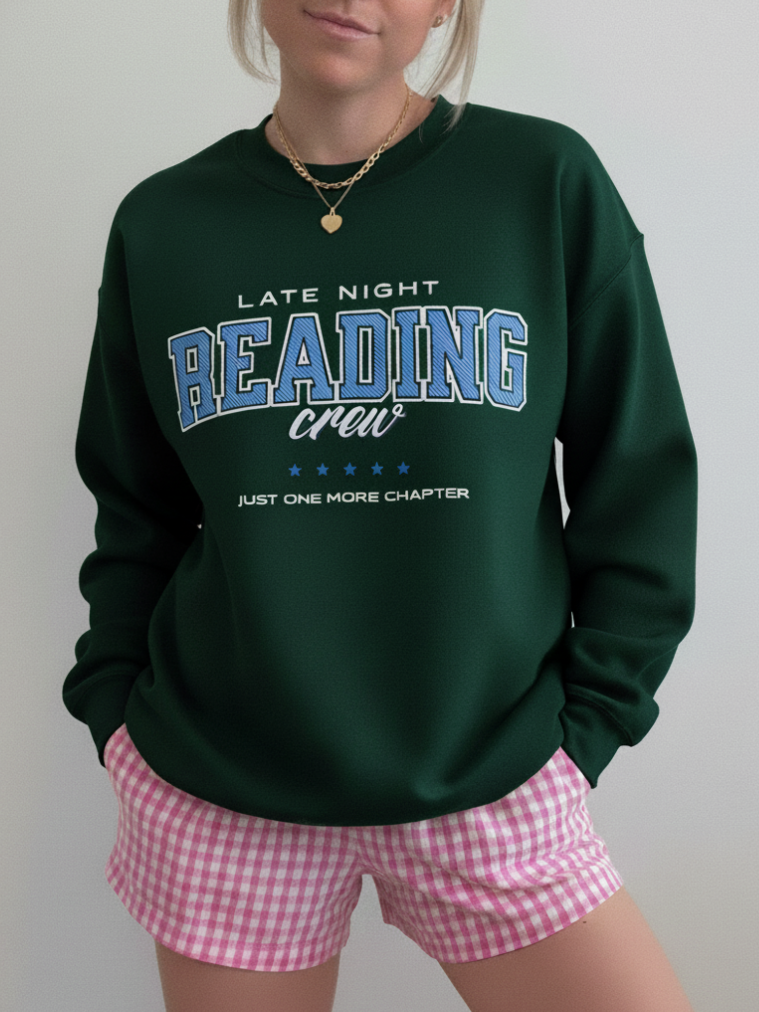 Forest green sweatshirt with vintage “Late Night Reading Crew” print and collegiate vibes, styled with pink gingham shorts.