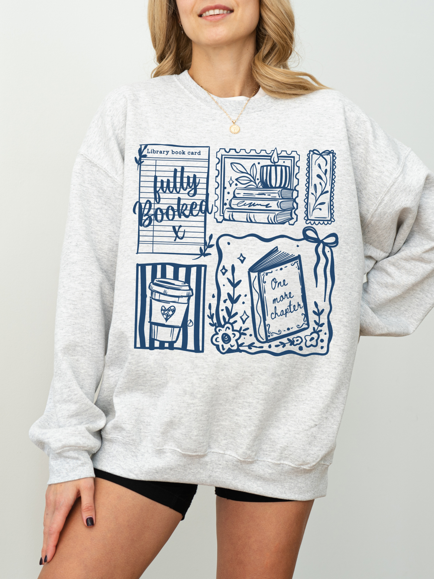 model wearing gray fully booked book lover sweatshirt with illustrated reading design relaxed cozy casual outfit
